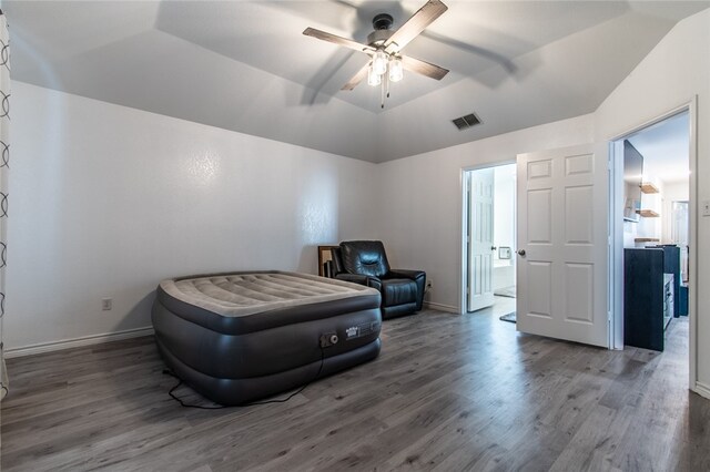 bedroom featuring dark hardwood / wood-style flooring, vaulted ceiling, and ceiling fan