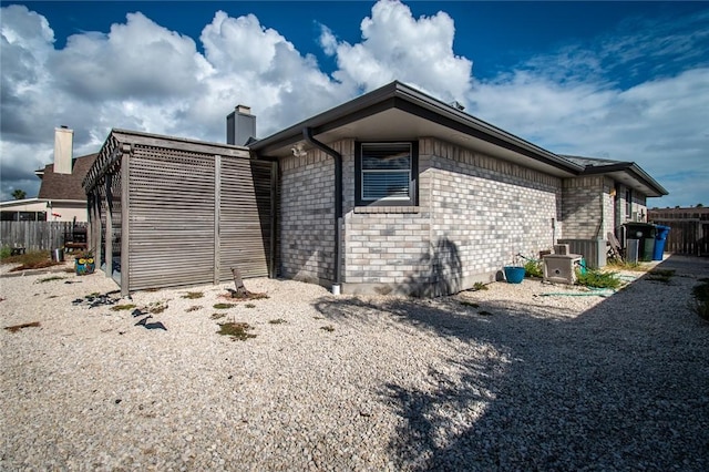 15957 San Felipe Dr, Corpus Christi, TX 78418 - rear view of house with a chimney, brick siding, and fence