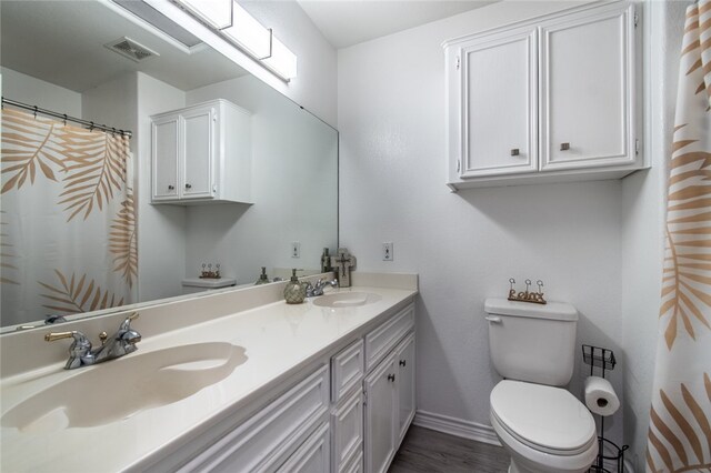 bathroom with hardwood / wood-style flooring, vanity, and toilet