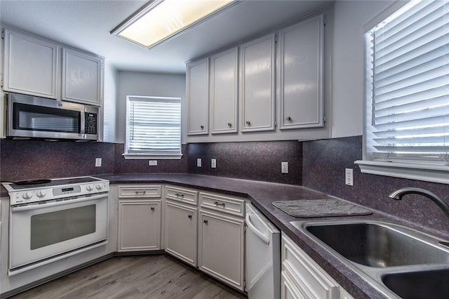 15957 San Felipe Dr, Corpus Christi, TX 78418 - kitchen with appliances with stainless steel finishes, a sink, dark countertops, and wood finished floors