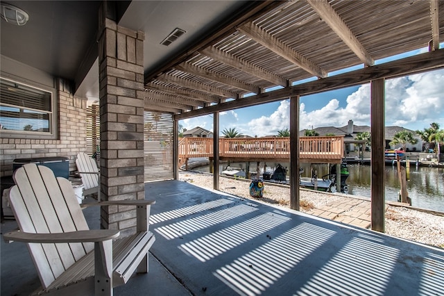 view of patio featuring a dock, a water view, and a pergola