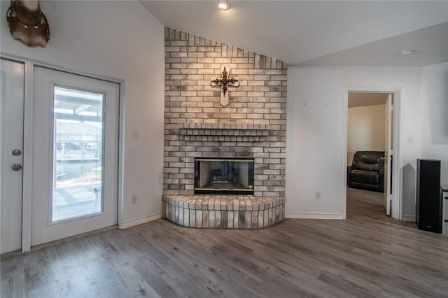 15957 San Felipe Dr, Corpus Christi, TX 78418 - unfurnished living room with vaulted ceiling, wood finished floors, a fireplace, and baseboards