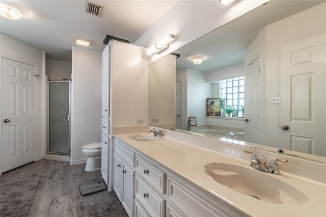 full bathroom with toilet, vanity, wood-type flooring, and separate shower and tub