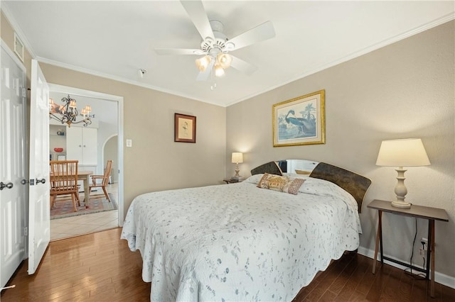 bedroom featuring ceiling fan, ornamental molding, and dark hardwood / wood-style floors