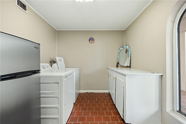 washroom featuring cabinets, ornamental molding, and washing machine and clothes dryer