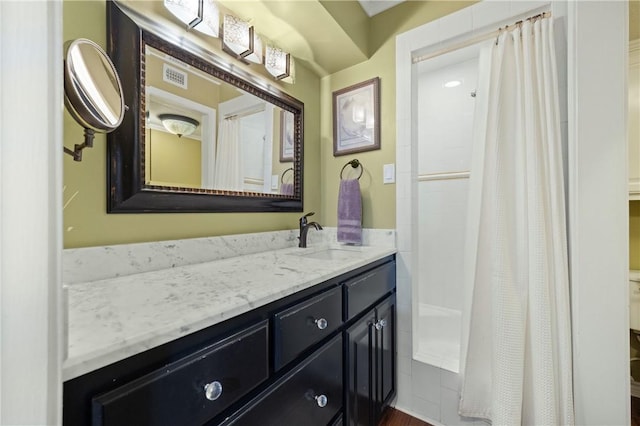 bathroom featuring walk in shower and vanity