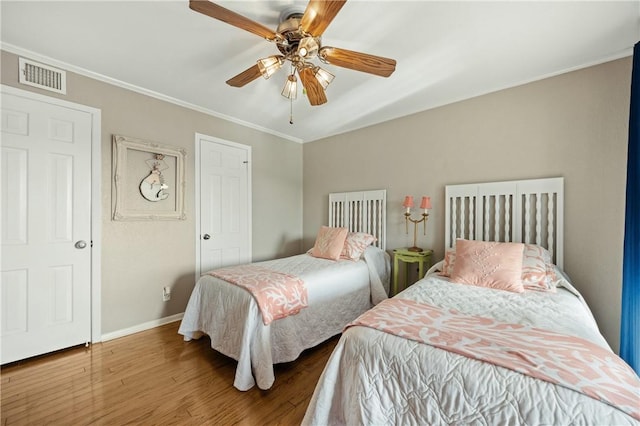 bedroom featuring ceiling fan, ornamental molding, and hardwood / wood-style flooring