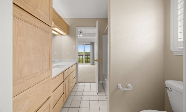 bathroom featuring vanity, tile patterned flooring, toilet, a washtub, and ceiling fan