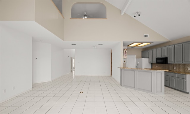 kitchen featuring tasteful backsplash, gray cabinetry, high vaulted ceiling, ceiling fan, and white fridge