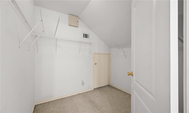 spacious closet with vaulted ceiling and carpet flooring