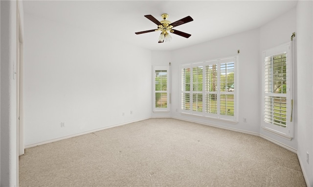 spare room featuring light colored carpet and ceiling fan