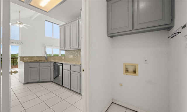 kitchen with sink, lofted ceiling with beams, stainless steel dishwasher, gray cabinets, and decorative backsplash