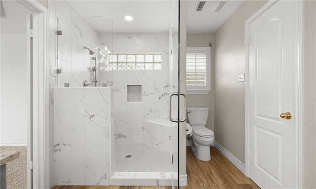 bathroom with toilet, an enclosed shower, and hardwood / wood-style flooring