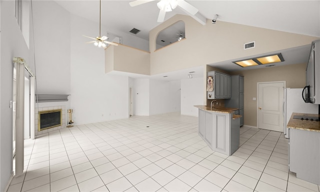 kitchen featuring high vaulted ceiling, ceiling fan, and gray cabinets