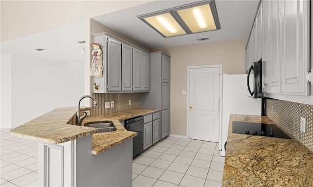 kitchen featuring sink, black appliances, kitchen peninsula, gray cabinets, and decorative backsplash