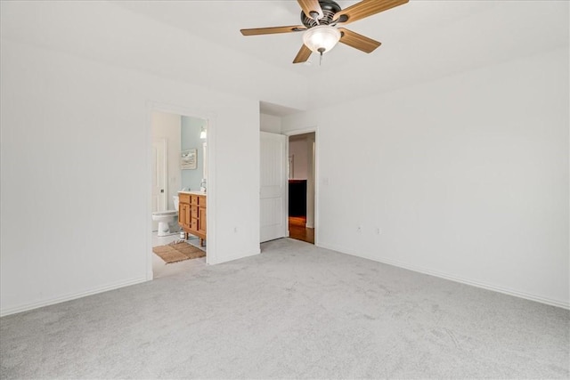 unfurnished bedroom featuring baseboards, a ceiling fan, connected bathroom, and light colored carpet