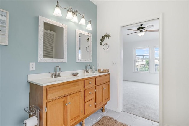 bathroom featuring double vanity, ceiling fan, tile patterned flooring, a sink, and baseboards
