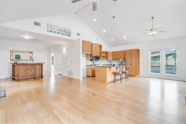 3401 Laguna Shores Rd, Corpus Christi, TX 78418 - living area with high vaulted ceiling, ceiling fan, light wood-style flooring, and visible vents