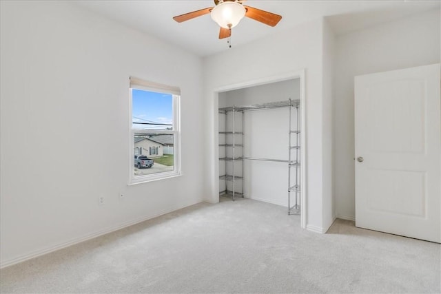 unfurnished bedroom featuring ceiling fan, baseboards, carpet, and a closet