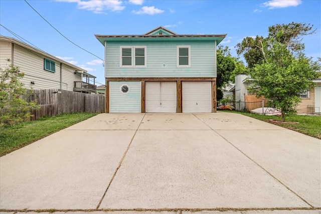 garage featuring fence and driveway