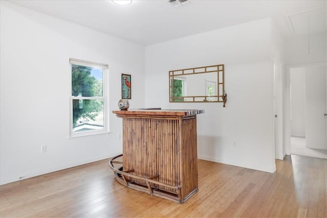 bar featuring baseboards, a dry bar, light wood-type flooring, and visible vents
