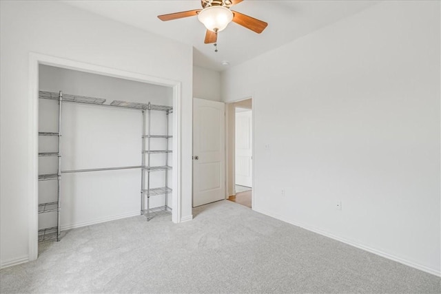 unfurnished bedroom featuring a ceiling fan, baseboards, carpet, and a closet