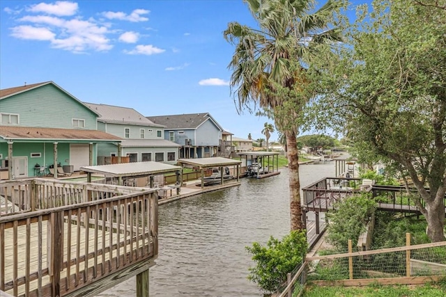 dock area featuring a water view, boat lift, and a residential view