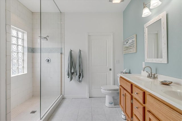 full bath featuring double vanity, tile patterned flooring, a sink, toilet, and tiled shower