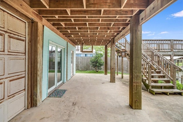 view of patio with stairs and fence