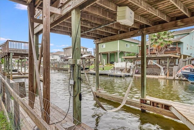 view of dock featuring boat lift, a residential view, and a water view