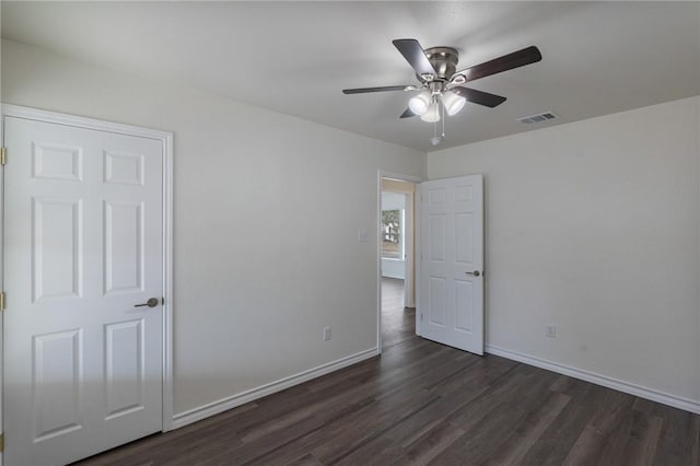 unfurnished bedroom with a ceiling fan, baseboards, visible vents, and dark wood-style flooring