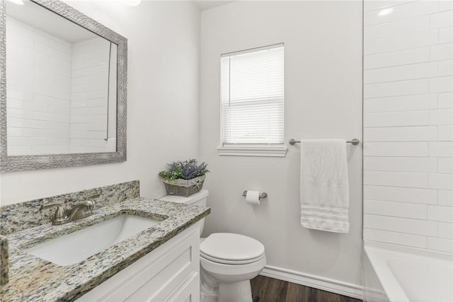 bathroom with vanity, wood finished floors, toilet, and baseboards