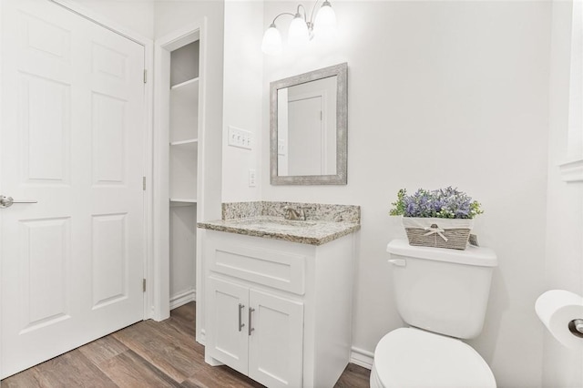 bathroom with toilet, wood finished floors, and vanity