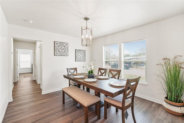 dining space featuring an inviting chandelier, baseboards, and dark wood-type flooring