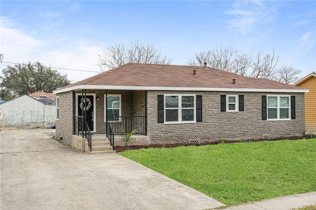 ranch-style house featuring a shingled roof, stone siding, covered porch, and a front lawn