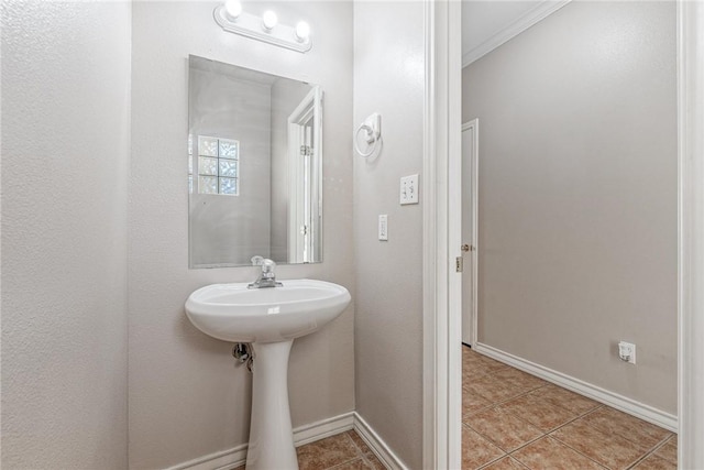 bathroom featuring tile patterned flooring, baseboards, and ornamental molding