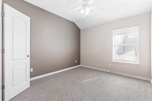 carpeted spare room featuring ceiling fan, baseboards, and lofted ceiling