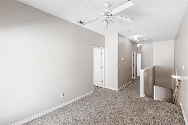 spare room featuring a ceiling fan, carpet flooring, baseboards, and visible vents