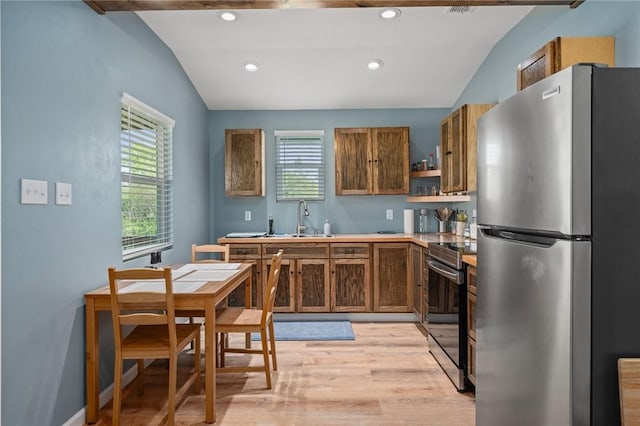 kitchen with open shelves, a sink, light wood-style floors, vaulted ceiling, and stainless steel appliances