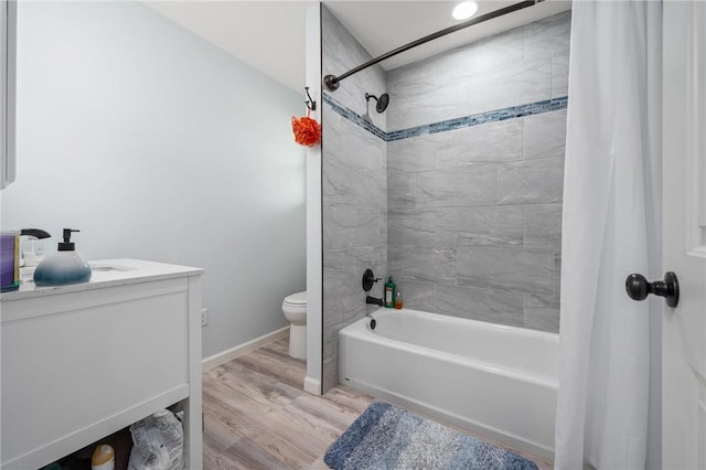 bathroom with shower / tub combo, vanity, baseboards, toilet, and wood finished floors
