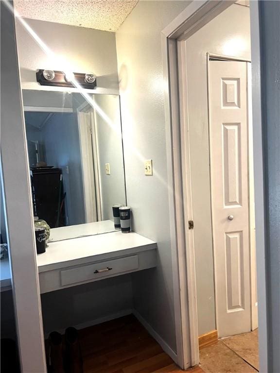 bathroom with hardwood / wood-style floors, vanity, and a textured ceiling