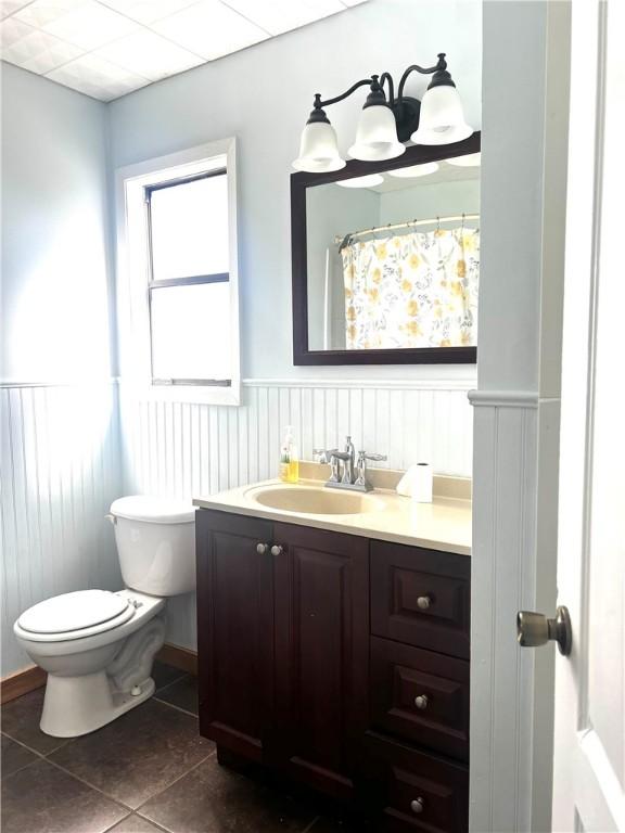 bathroom featuring tile patterned flooring, vanity, and toilet