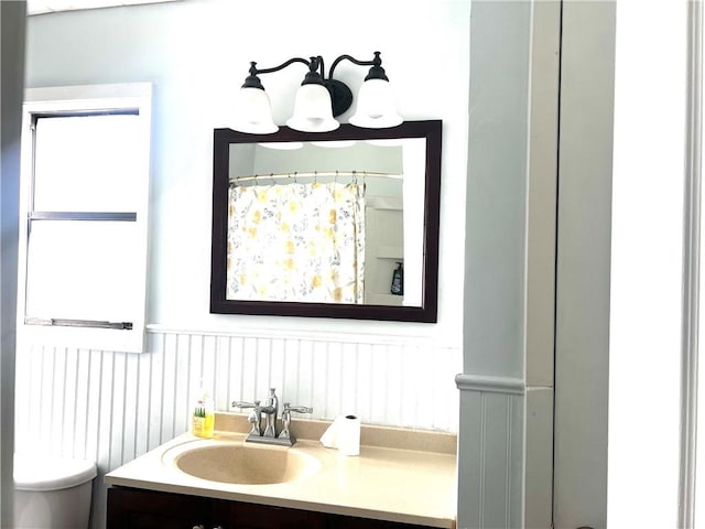 bathroom with a shower with shower curtain, vanity, and toilet