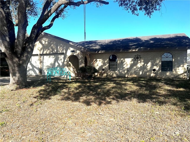 view of front of property featuring a front lawn and a garage