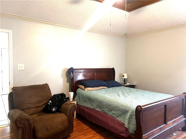 bedroom with hardwood / wood-style flooring, ceiling fan, ornamental molding, and a textured ceiling