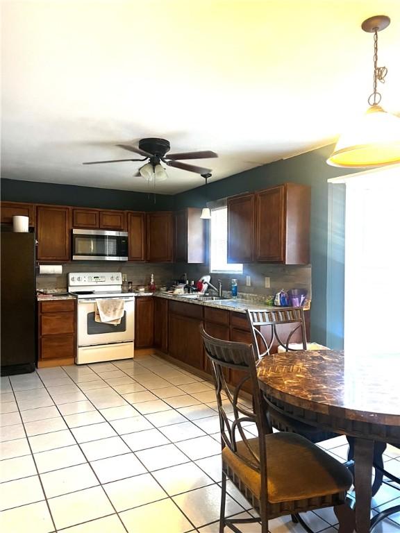 kitchen with pendant lighting, white electric stove, fridge, and sink