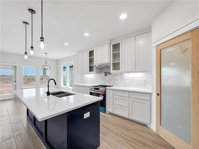 6222 Sadie St, Corpus Christi, TX 78415 - kitchen with an island with sink, stainless steel range, a sink, white cabinetry, and decorative backsplash