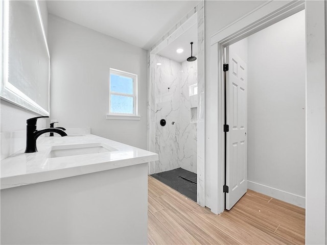 6222 Sadie St, Corpus Christi, TX 78415 - bathroom with a marble finish shower, baseboards, double vanity, wood finished floors, and a sink