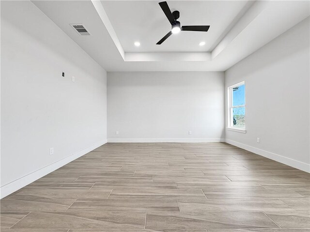 6222 Sadie St, Corpus Christi, TX 78415 - spare room featuring light wood finished floors, visible vents, ceiling fan, baseboards, and a tray ceiling