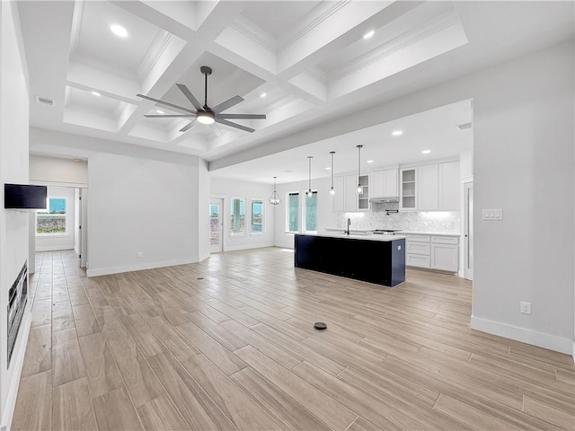 6222 Sadie St, Corpus Christi, TX 78415 - unfurnished living room with beamed ceiling, a ceiling fan, coffered ceiling, light wood finished floors, and baseboards